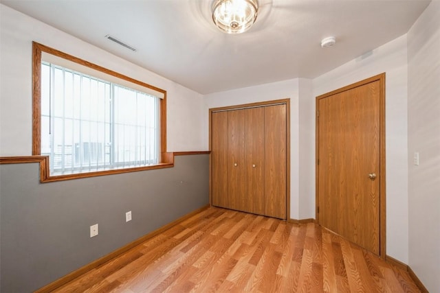 unfurnished bedroom with light hardwood / wood-style floors and a closet