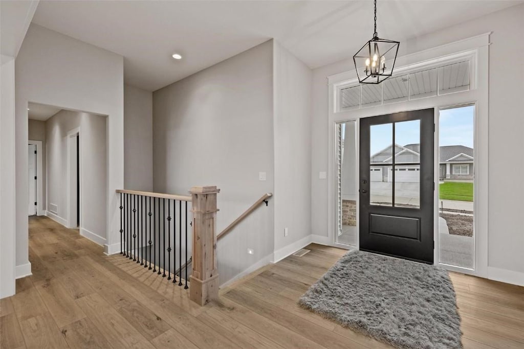 foyer entrance featuring a notable chandelier and light hardwood / wood-style flooring