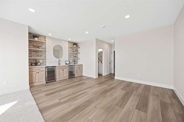 bar with light hardwood / wood-style flooring, beverage cooler, and light brown cabinets