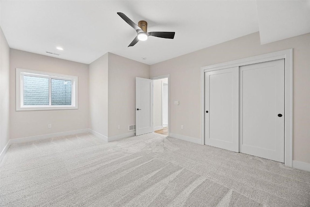 unfurnished bedroom featuring light carpet, ceiling fan, and a closet