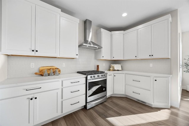 kitchen featuring wall chimney range hood, white cabinetry, stainless steel range with gas stovetop, and light hardwood / wood-style floors