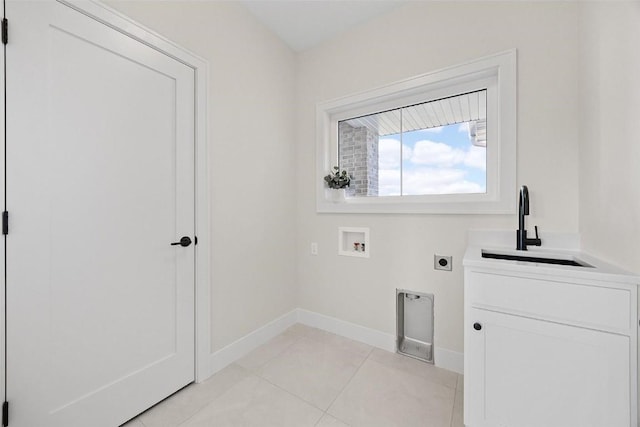 clothes washing area featuring light tile patterned flooring, sink, cabinets, washer hookup, and hookup for an electric dryer