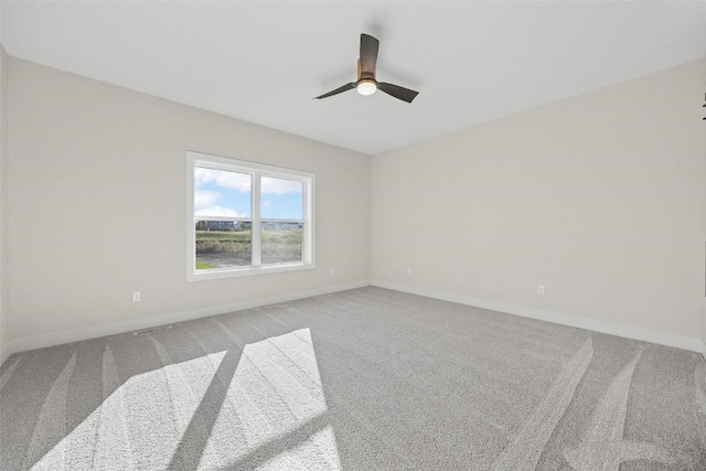 carpeted spare room featuring ceiling fan