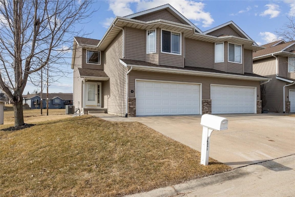 view of front of house featuring a garage, central AC unit, and a front lawn