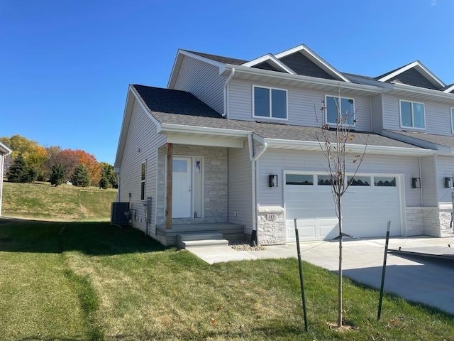 view of front facade with a garage, cooling unit, and a front yard