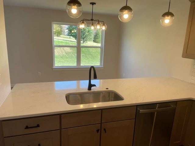 kitchen featuring pendant lighting, dishwasher, sink, light stone counters, and kitchen peninsula