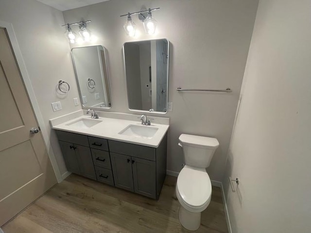 bathroom with hardwood / wood-style flooring, vanity, and toilet