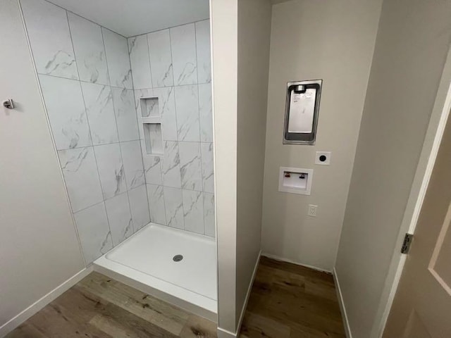 bathroom with wood-type flooring and tiled shower