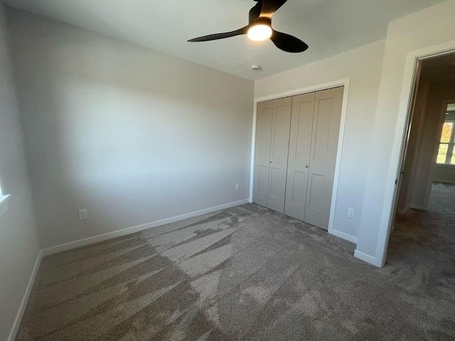 unfurnished bedroom featuring a closet, ceiling fan, and dark colored carpet