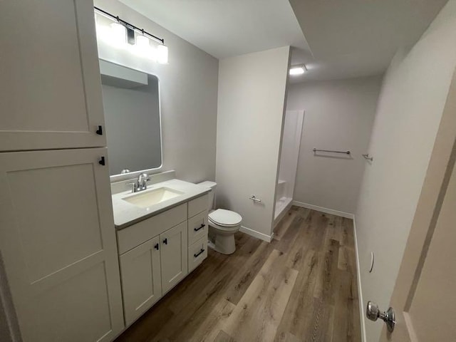 bathroom featuring vanity, wood-type flooring, a shower, and toilet