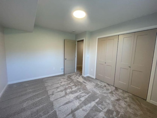 unfurnished bedroom with light carpet and a closet