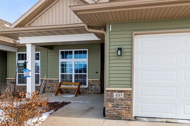 doorway to property with a garage and covered porch