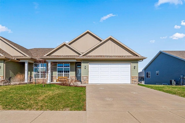 405 Ridge View Dr, West Branch, IA 52358 - craftsman-style house with stone siding, concrete driveway, a garage, and a front yard