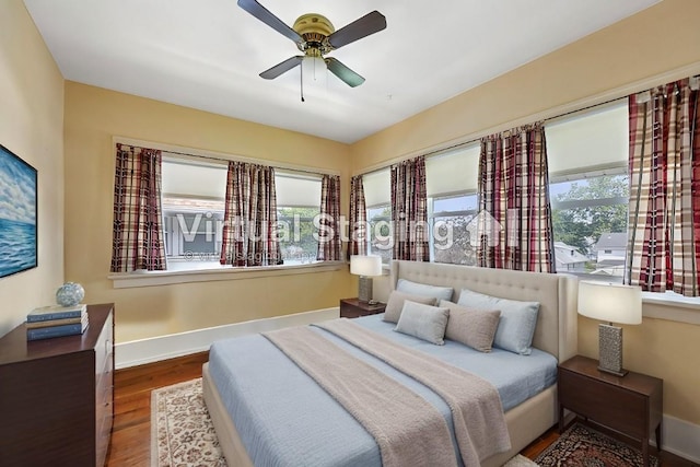 bedroom with hardwood / wood-style flooring, ceiling fan, and multiple windows