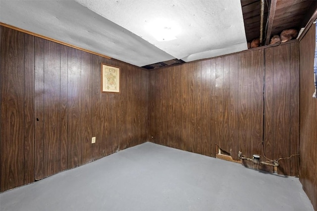 basement featuring wood walls