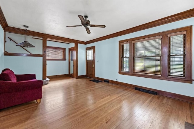 living room with crown molding, light hardwood / wood-style flooring, and ceiling fan