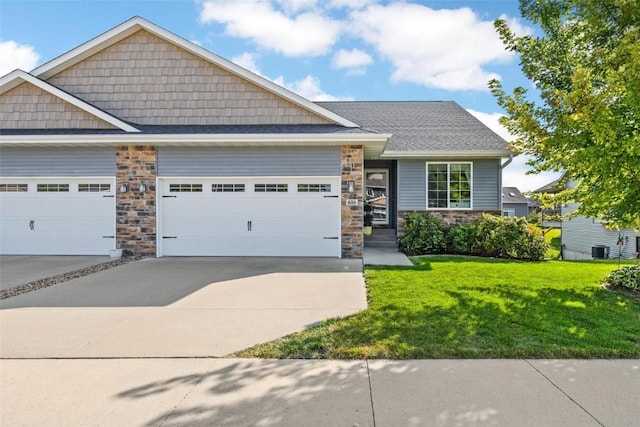 view of front of house featuring central AC unit, a garage, and a front lawn