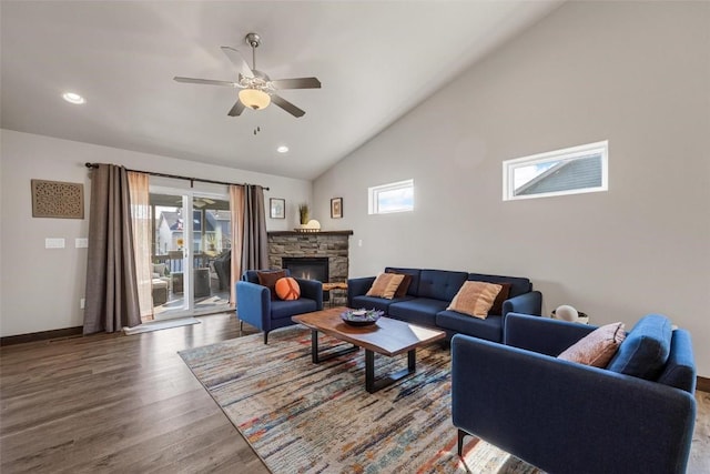 living room featuring high vaulted ceiling, a stone fireplace, hardwood / wood-style floors, and ceiling fan