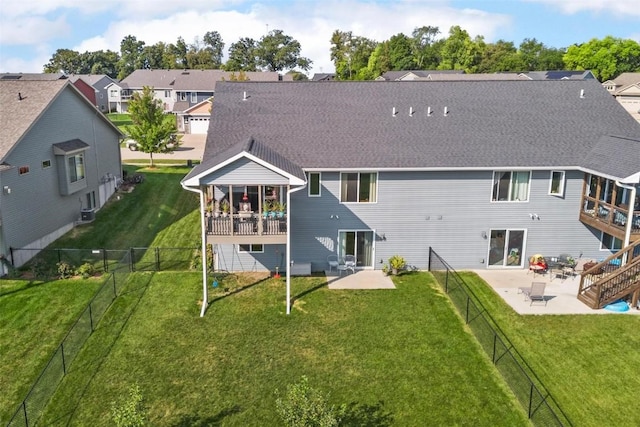 back of house with a yard and a patio