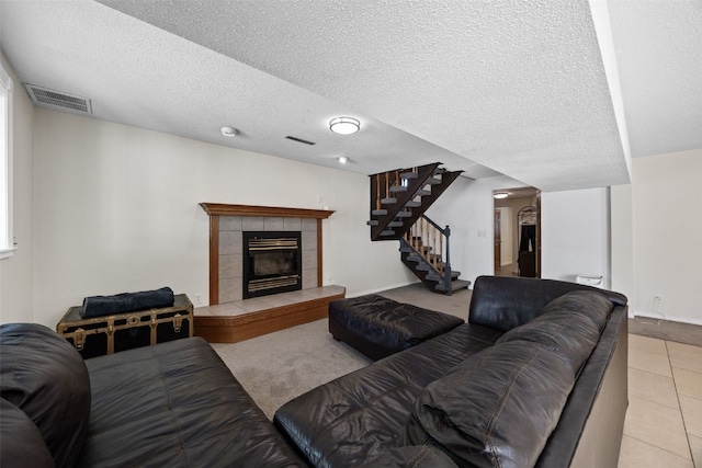 tiled living room with a fireplace and a textured ceiling