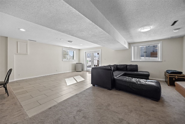 carpeted living room with french doors and a textured ceiling