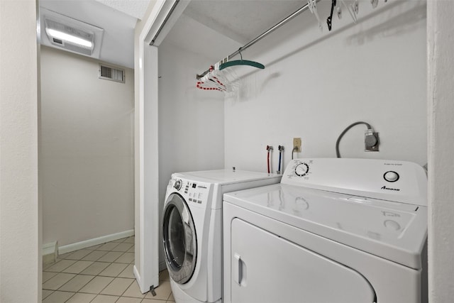 washroom featuring washing machine and clothes dryer and light tile patterned flooring