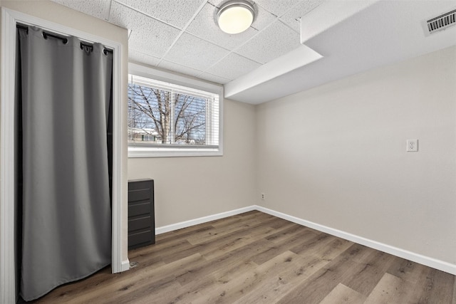 unfurnished bedroom with wood-type flooring and a paneled ceiling