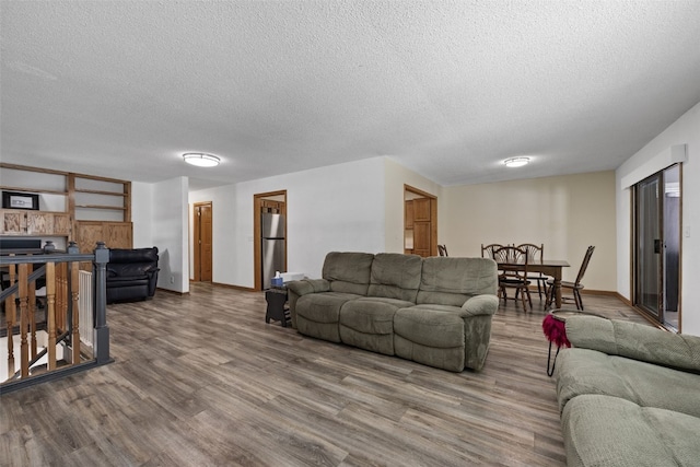 living room featuring wood-type flooring and a textured ceiling