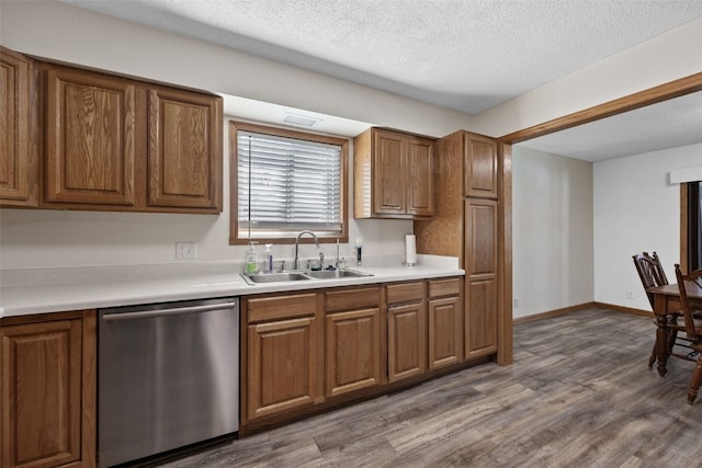 kitchen featuring sink, a textured ceiling, hardwood / wood-style floors, and dishwasher