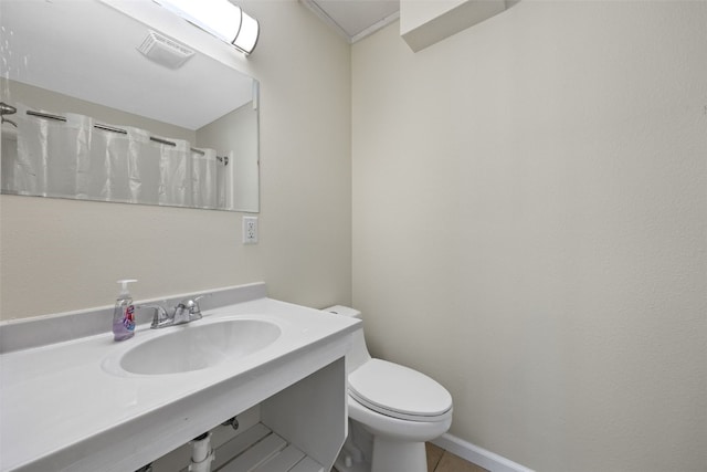 bathroom featuring toilet, tile patterned flooring, and sink