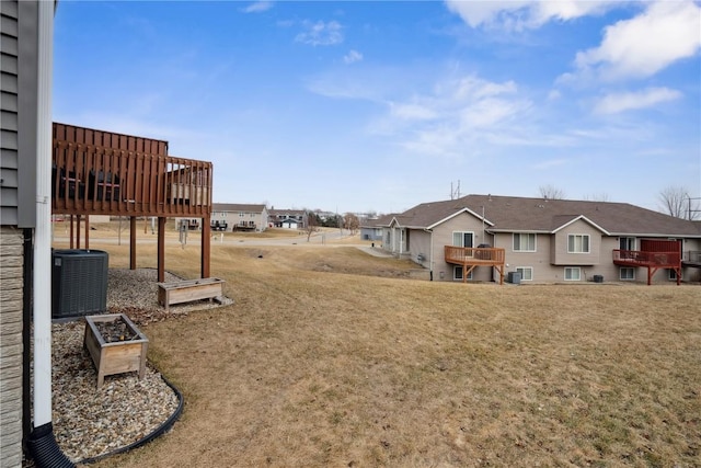 view of yard with central AC and a deck