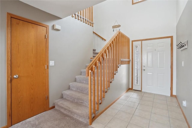 tiled foyer with a towering ceiling