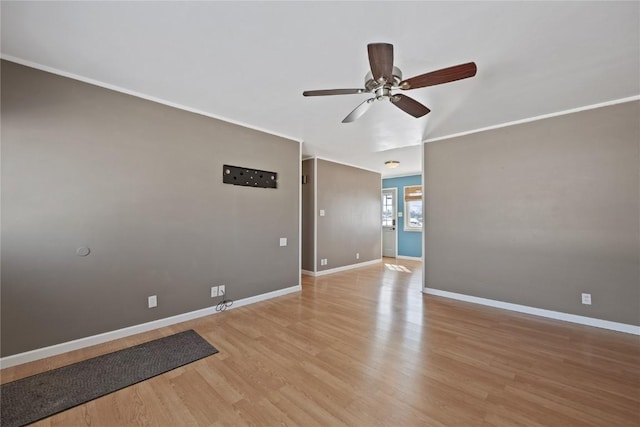 empty room with ceiling fan, ornamental molding, and light wood-type flooring