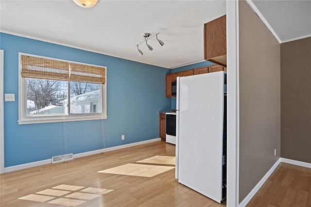 kitchen featuring electric stove, light hardwood / wood-style floors, and white refrigerator