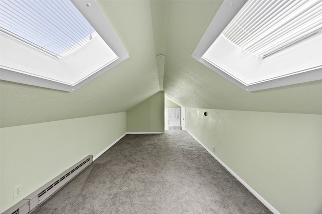 additional living space with light carpet, lofted ceiling with skylight, and baseboard heating