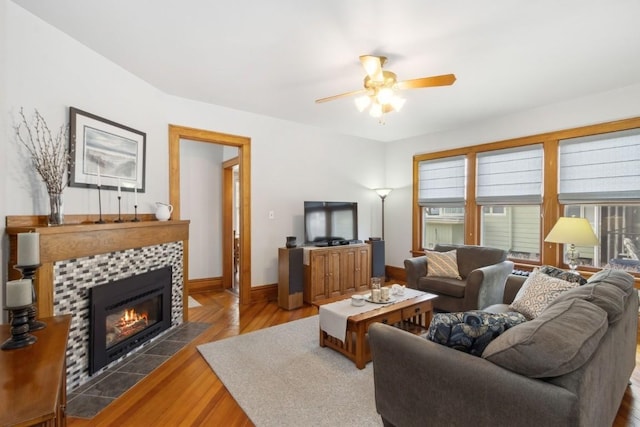 living room featuring ceiling fan, wood-type flooring, and a fireplace