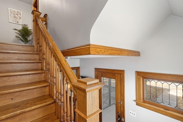 stairway featuring vaulted ceiling and a healthy amount of sunlight