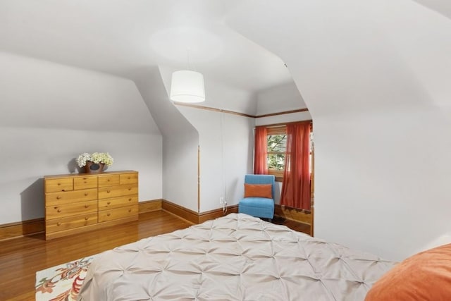 bedroom with wood-type flooring and vaulted ceiling