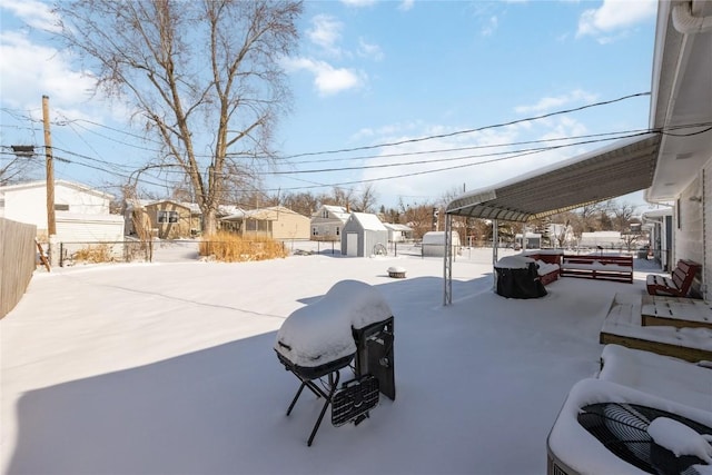 yard covered in snow featuring a storage unit and a pergola