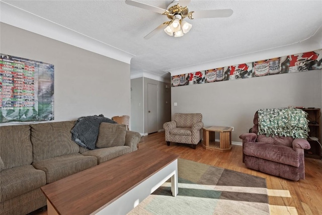 living room with a textured ceiling, wood-type flooring, and ceiling fan