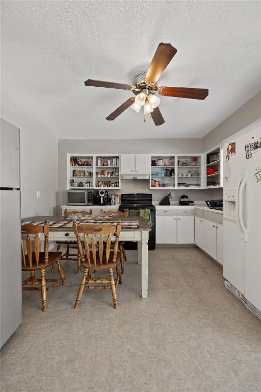 kitchen featuring refrigerator, white cabinetry, black electric range, white refrigerator with ice dispenser, and a textured ceiling