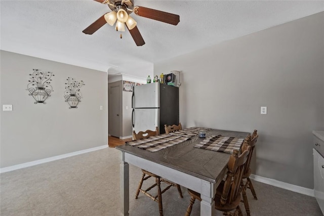 dining area with ceiling fan and a textured ceiling