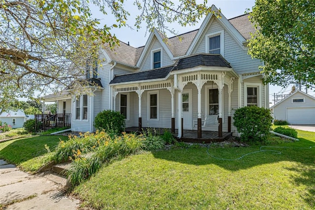 view of front facade featuring a front yard, covered porch, and roof with shingles