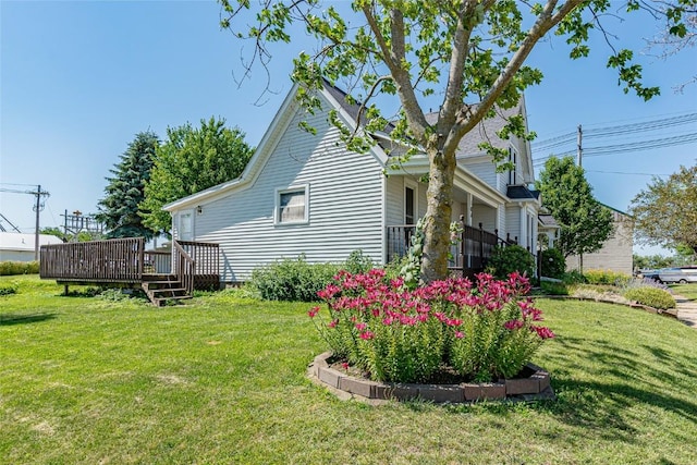 view of side of home with a wooden deck and a yard