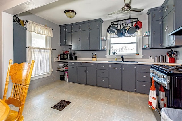 kitchen featuring hanging light fixtures, gas range, a wealth of natural light, and sink