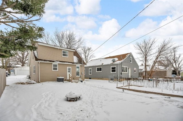 snow covered property featuring central AC