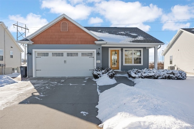 view of front of home with central AC unit and a garage