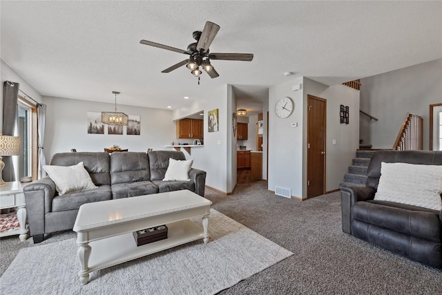 carpeted living room featuring ceiling fan and a textured ceiling