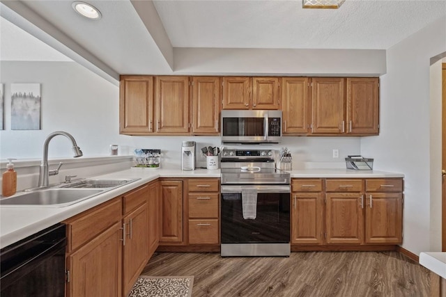 kitchen featuring stainless steel appliances, dark hardwood / wood-style floors, sink, and a textured ceiling