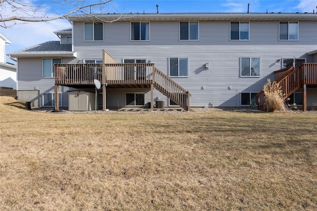 rear view of property with a wooden deck and a yard